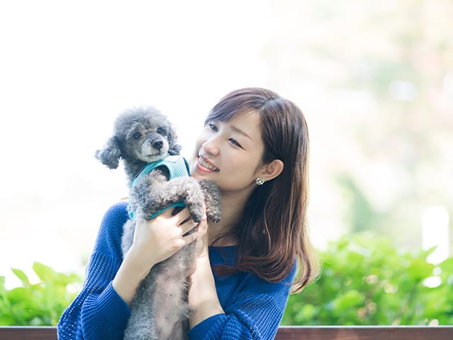 ワンちゃんを抱きかかえる女性